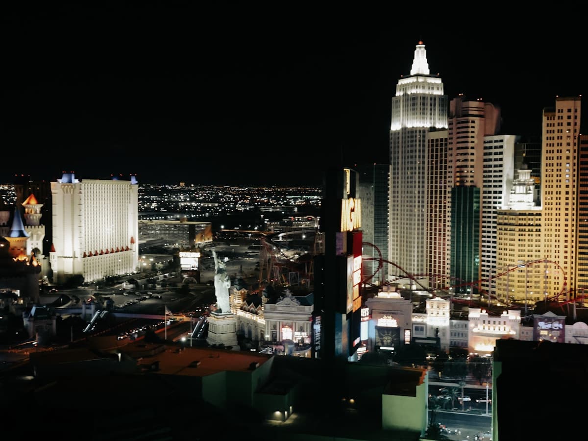 The Las Vegas Strip lit up at night with neon, hotels, and traffic streaks below the desert sky.
