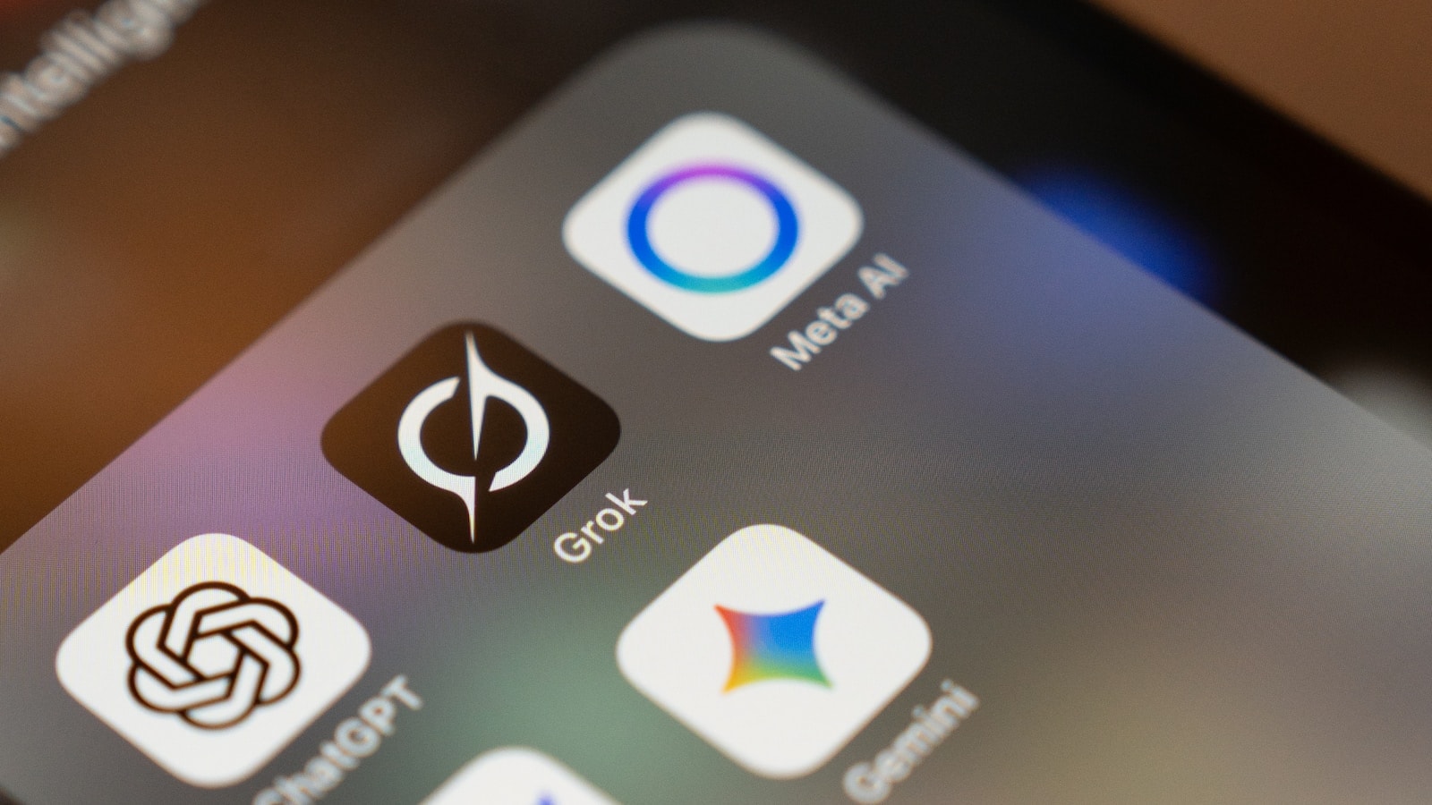 A close-up of a smartphone screen showing the icons of multiple AI assistants (ChatGPT, Grok, Meta AI, Gemini) — the new generation of generative engines that compose answers directly instead of returning lists of links.
